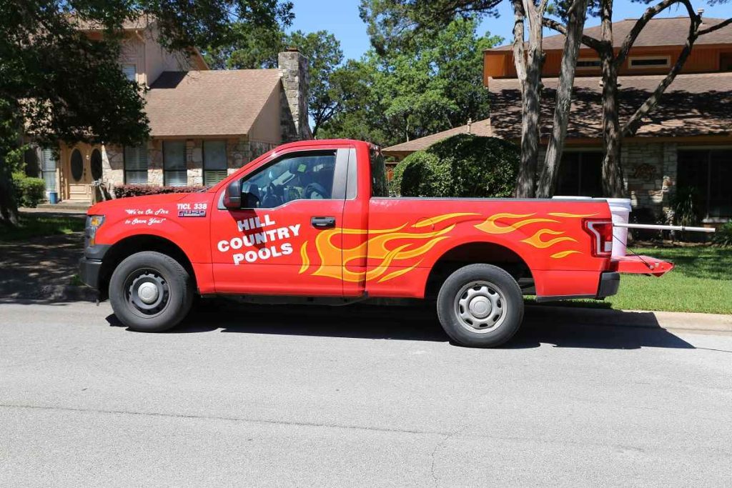 Hill Country Pools service van parked, branded with company logo and graphics
