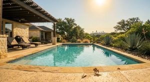 Pool maintenance equipment including a pump, sand filter, skimmer basket, chemical test kits, a skimmer pole, and a bag of pool salt arranged on a concrete patio next to a clear backyard swimming pool on a sunny day in Austin, Texas.